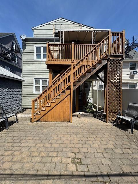 back of house featuring a wooden deck, stairs, and a patio area
