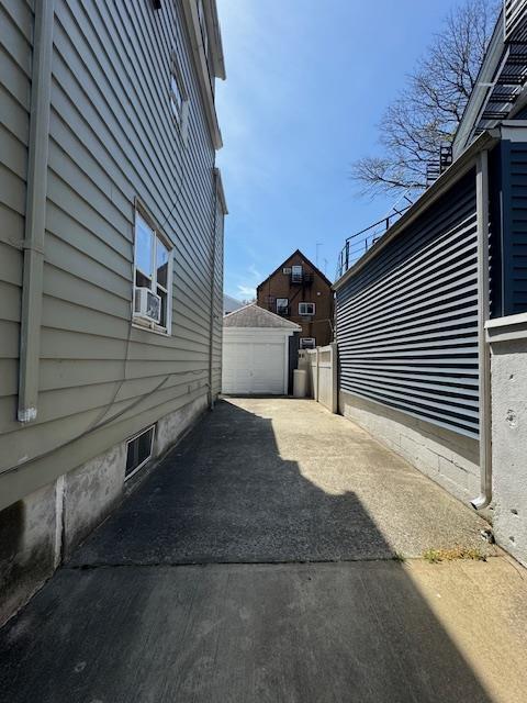 view of side of property with driveway and a detached garage