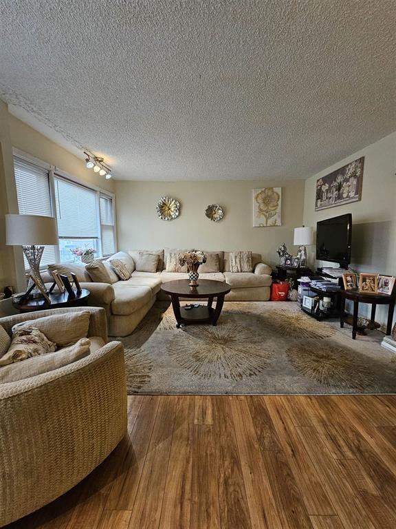 living room featuring a textured ceiling and wood finished floors