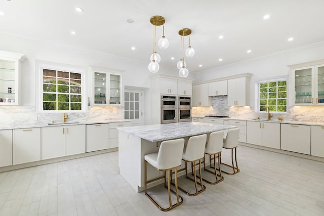 kitchen featuring tasteful backsplash, stainless steel appliances, crown molding, and a sink