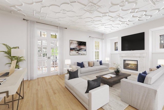 living area with light wood-style flooring, french doors, and a fireplace