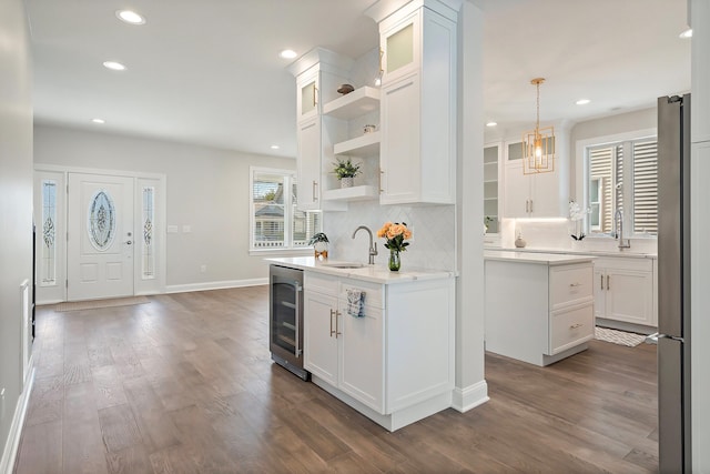 kitchen with dark hardwood / wood-style flooring, backsplash, pendant lighting, white cabinets, and wine cooler