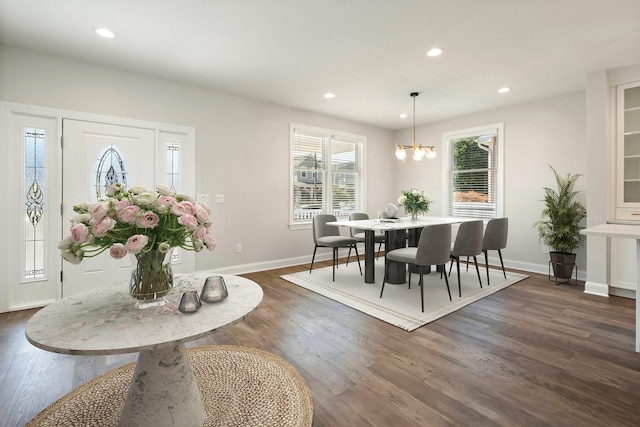 dining space with dark hardwood / wood-style flooring and a chandelier