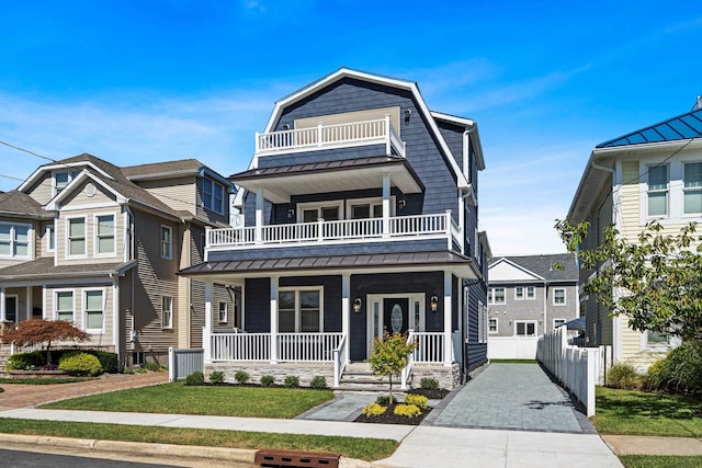 view of front facade featuring a balcony and a front yard