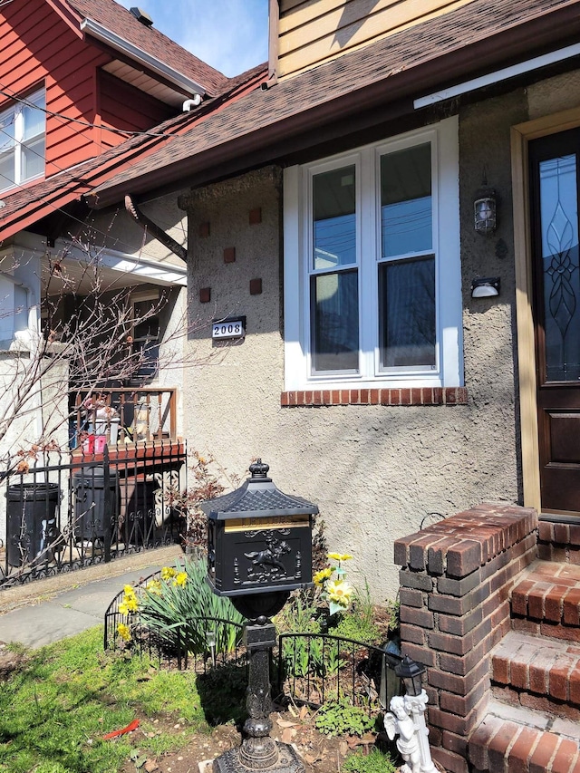 view of property exterior with a shingled roof and stucco siding
