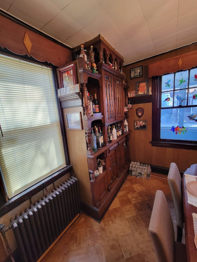 bar featuring wooden walls and radiator heating unit