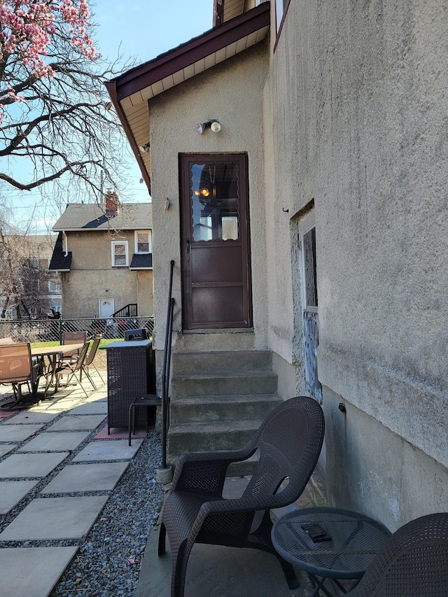 doorway to property with a patio area and stucco siding