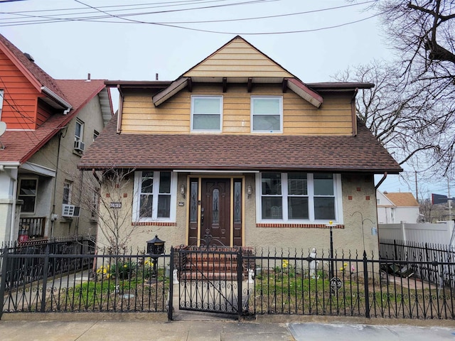 view of front facade with a fenced front yard, a shingled roof, and stucco siding