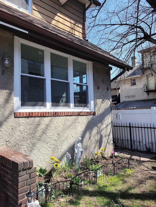 view of side of home featuring fence