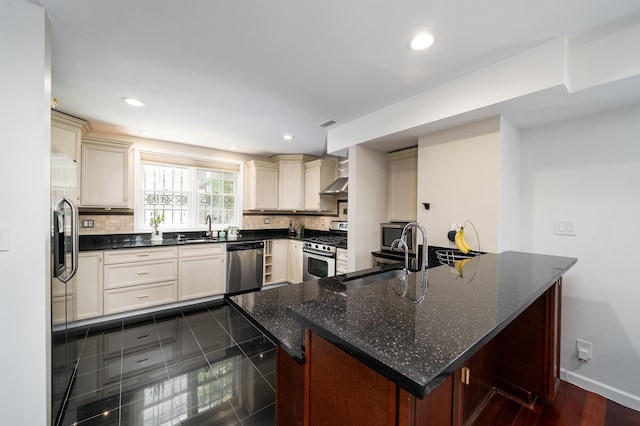 25 Poplar St, Jersey City, NJ 07307 - kitchen with stainless steel appliances, wall chimney range hood, tasteful backsplash, recessed lighting, and cream cabinetry