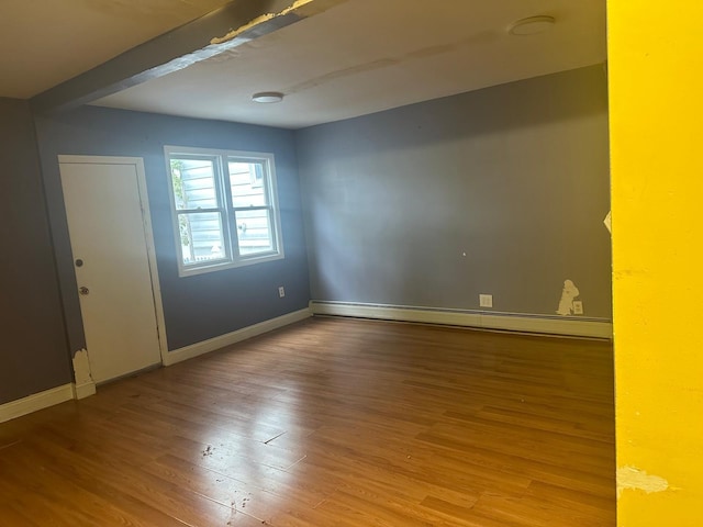 unfurnished room featuring baseboard heating and light hardwood / wood-style flooring