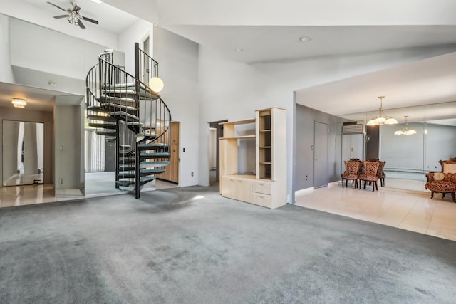 living area with stairs, a towering ceiling, carpet flooring, baseboards, and a ceiling fan