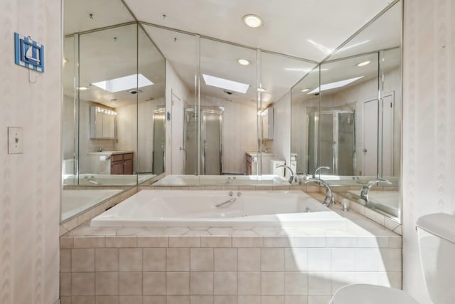 bathroom with recessed lighting, a skylight, a shower stall, and a garden tub