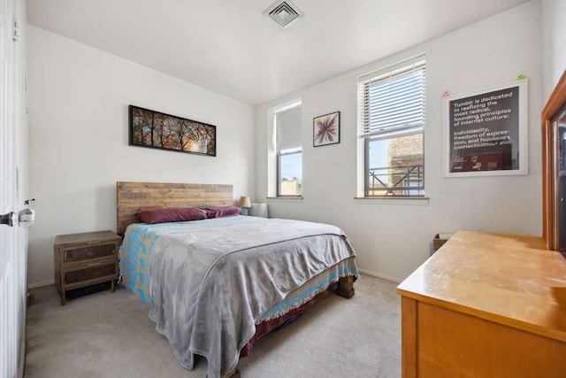 bedroom with visible vents, light colored carpet, and baseboards