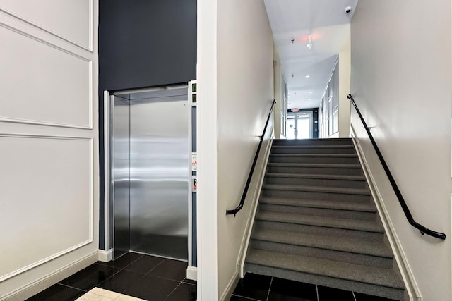 staircase with tile patterned flooring and elevator