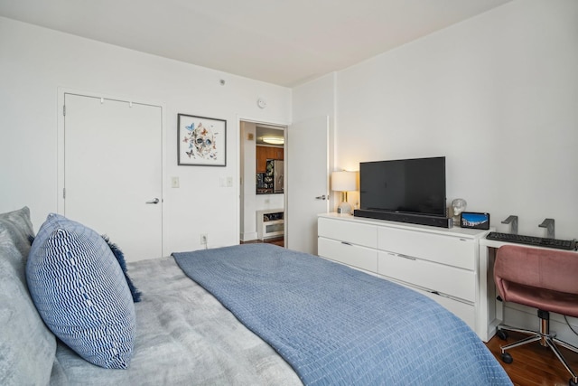 bedroom featuring stainless steel fridge and wood-type flooring