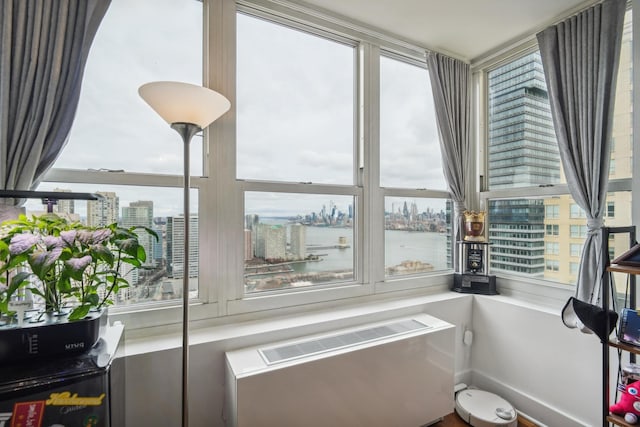 interior space with radiator, a water view, and plenty of natural light