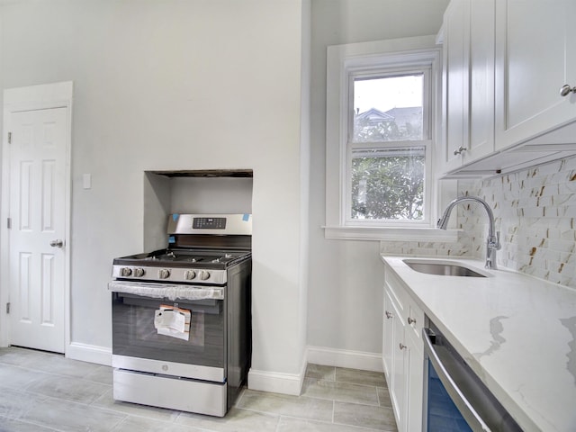 33 Duer Pl, Weehawken, NJ 07086 - kitchen with gas stove, light stone counters, white cabinetry, decorative backsplash, and dishwashing machine