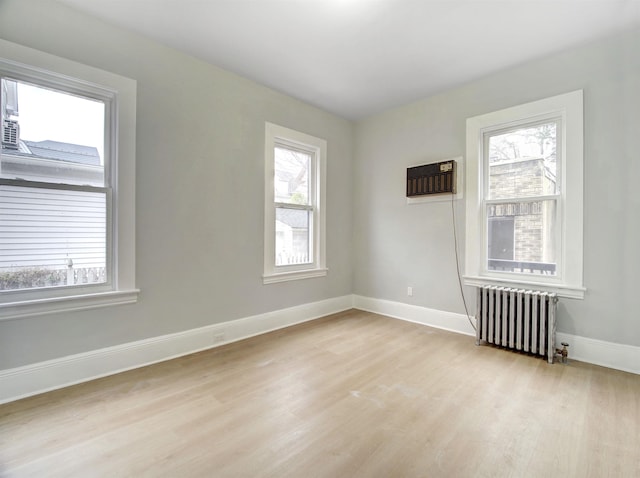 33 Duer Pl, Weehawken, NJ 07086 - unfurnished room with radiator heating unit, light wood-style floors, and a wall mounted air conditioner
