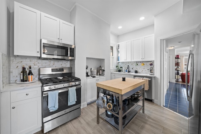 33 Duer Pl, Weehawken, NJ 07086 - kitchen with appliances with stainless steel finishes, white cabinets, recessed lighting, backsplash, and light wood-style flooring