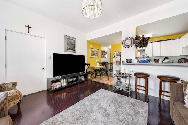 living room featuring dark hardwood / wood-style floors and an inviting chandelier