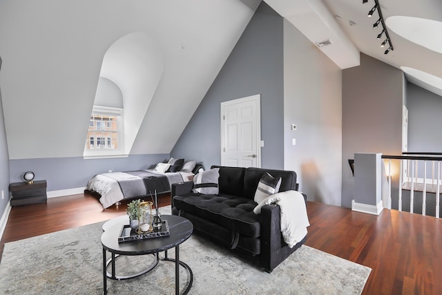 living room featuring rail lighting, wood-type flooring, and lofted ceiling