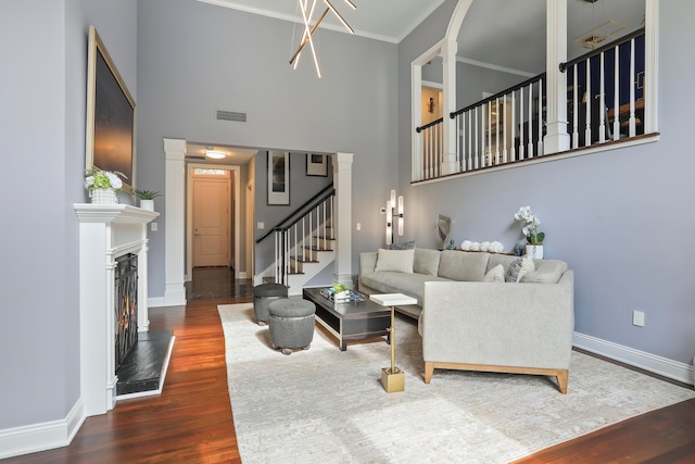 living room with ornamental molding, a high ceiling, and dark hardwood / wood-style floors