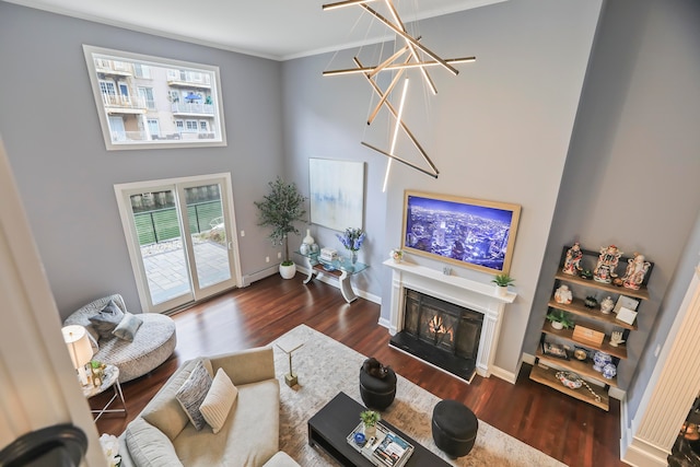 living room with dark hardwood / wood-style flooring, a chandelier, and crown molding