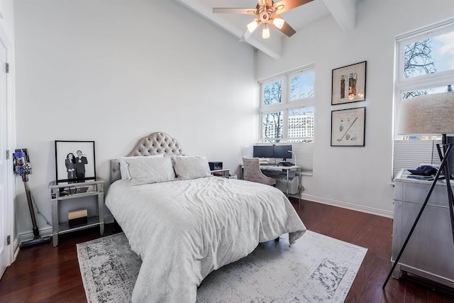 bedroom with multiple windows, dark hardwood / wood-style floors, and beam ceiling