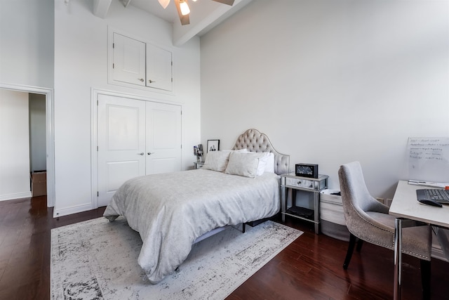 bedroom with a towering ceiling, dark hardwood / wood-style flooring, and a closet