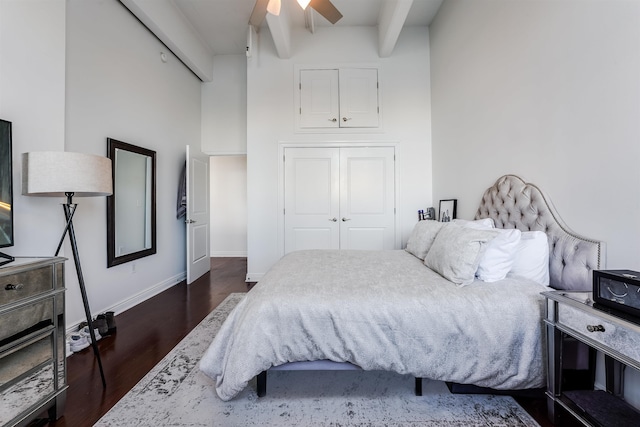 bedroom with beamed ceiling, ceiling fan, dark hardwood / wood-style floors, and a closet