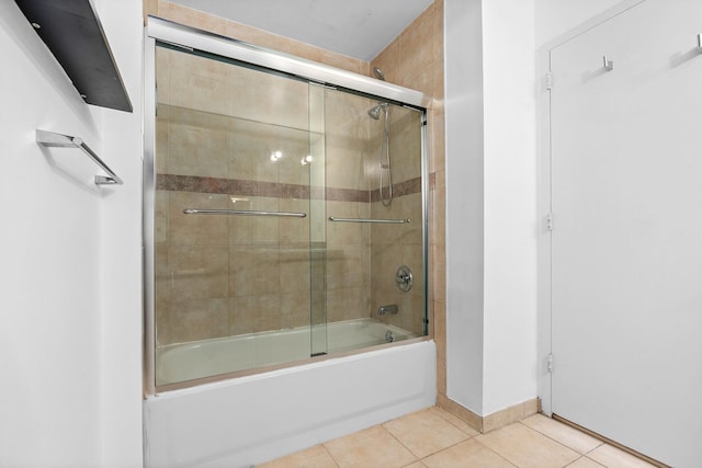 bathroom with tile patterned floors, enclosed tub / shower combo, and baseboards