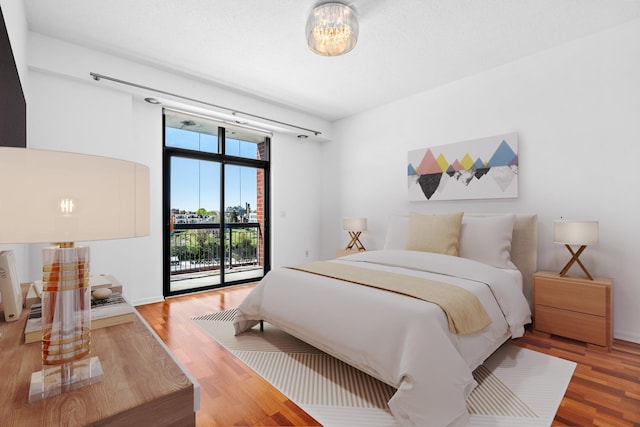bedroom featuring access to outside and wood finished floors
