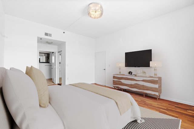 bedroom with visible vents and wood finished floors