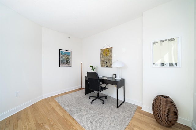 office space with baseboards and wood finished floors