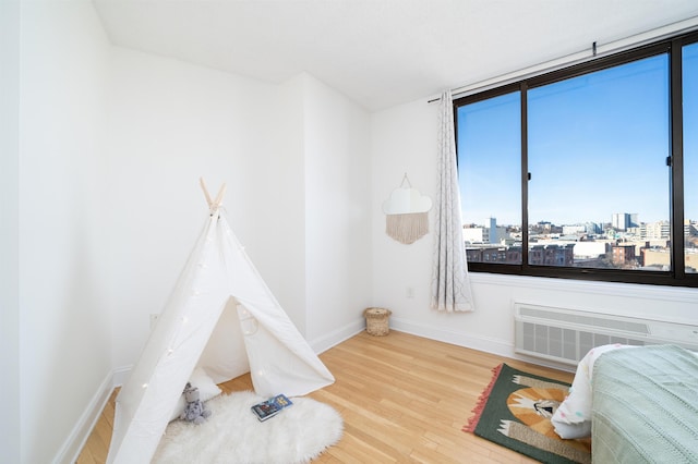 playroom with baseboards, wood finished floors, and a city view