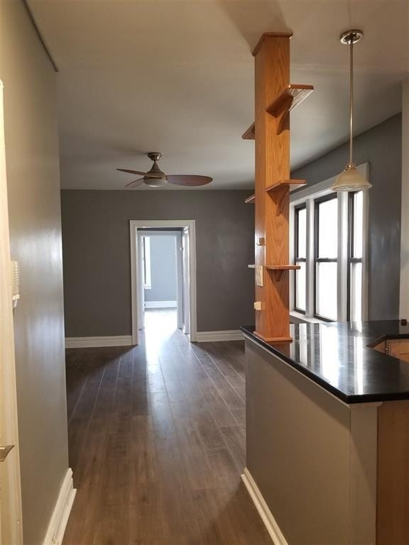 kitchen featuring pendant lighting, dark wood-type flooring, kitchen peninsula, and ceiling fan