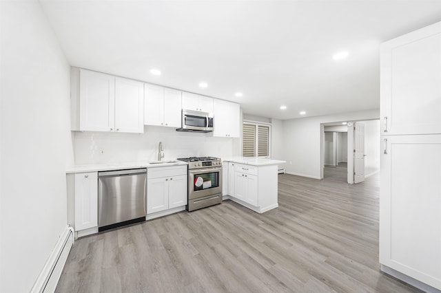 418 7th St, Union City, NJ 07087 - kitchen with stainless steel appliances, a baseboard radiator, light wood finished floors, light countertops, and white cabinets