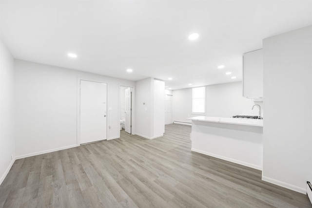 418 7th St, Union City, NJ 07087 - unfurnished living room featuring light wood finished floors, recessed lighting, a baseboard heating unit, and a baseboard radiator