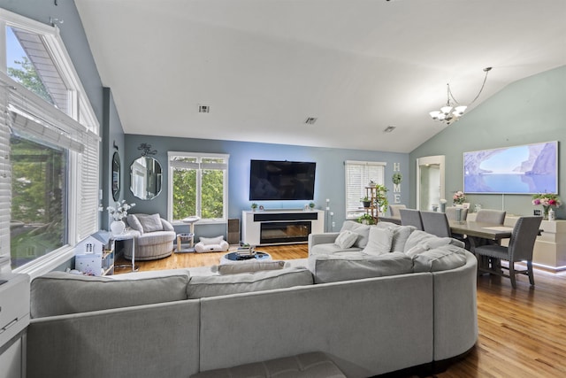 8901 Newkirk Ave, North Bergen, NJ 07047 - living room with wood finished floors, a chandelier, high vaulted ceiling, and a glass covered fireplace