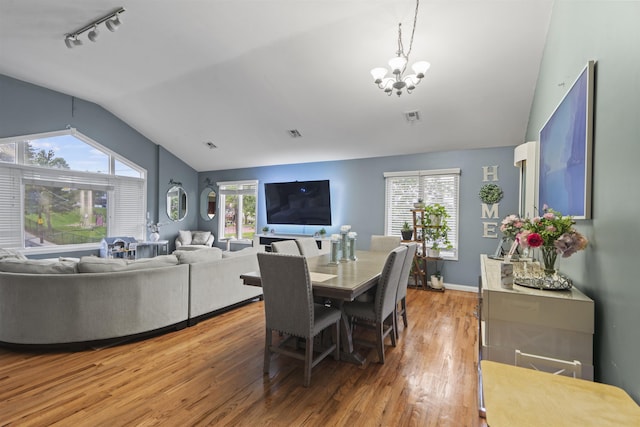 8901 Newkirk Ave, North Bergen, NJ 07047 - dining space featuring lofted ceiling, a chandelier, track lighting, light wood-type flooring, and plenty of natural light