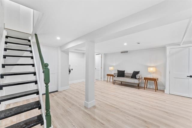 finished basement with light wood-style flooring, stairs, baseboards, and recessed lighting