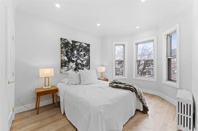 bedroom featuring radiator, light wood-type flooring, baseboards, and recessed lighting