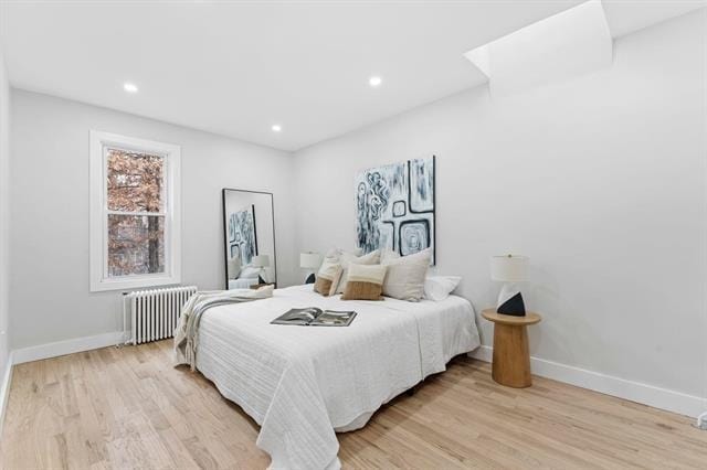 bedroom featuring baseboards, recessed lighting, light wood-style flooring, and radiator