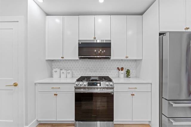 kitchen with white cabinetry, stainless steel appliances, and light countertops