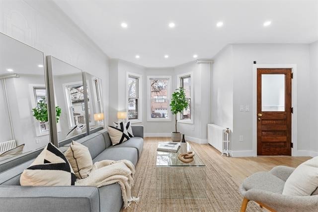 living room with recessed lighting, baseboards, light wood-style flooring, and radiator heating unit