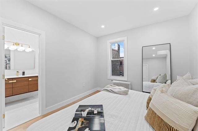 bedroom featuring recessed lighting, radiator, ensuite bath, light wood-type flooring, and baseboards