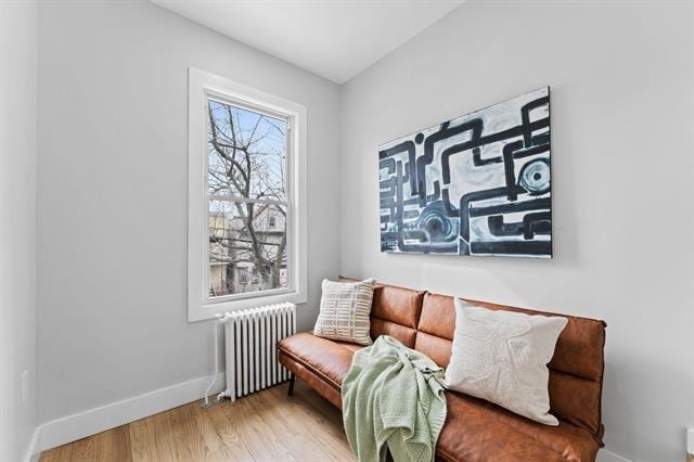 sitting room featuring radiator, baseboards, and wood finished floors