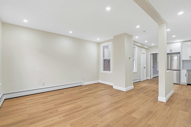 unfurnished living room with a baseboard radiator and light wood-type flooring