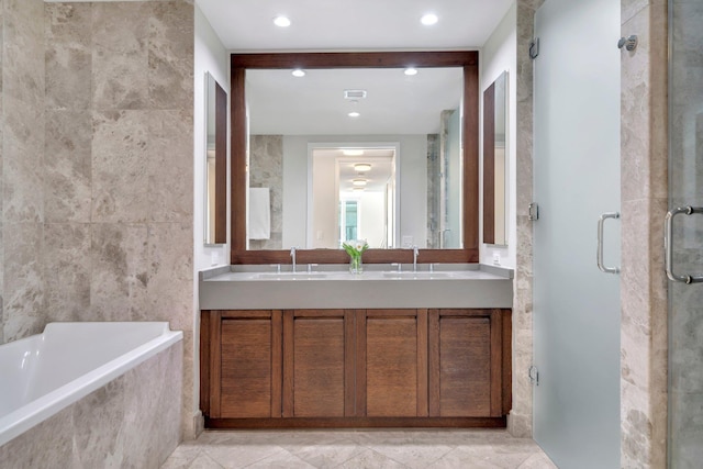 bathroom with a shower stall, a bath, double vanity, and a sink